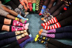 Image of people in a circle with their vibrant and crazy socks clearly visible.